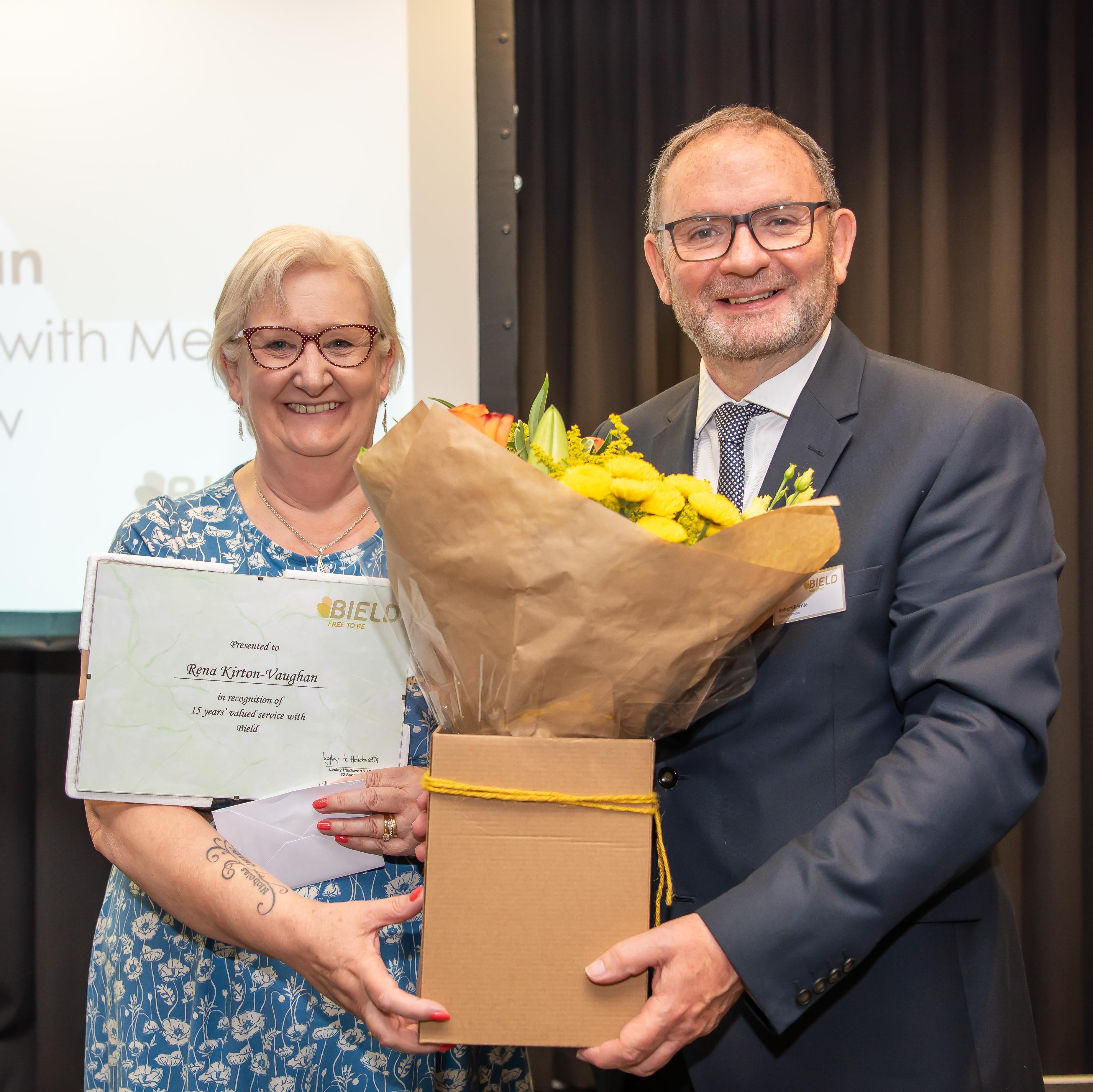 Board member presenting long service award to staff